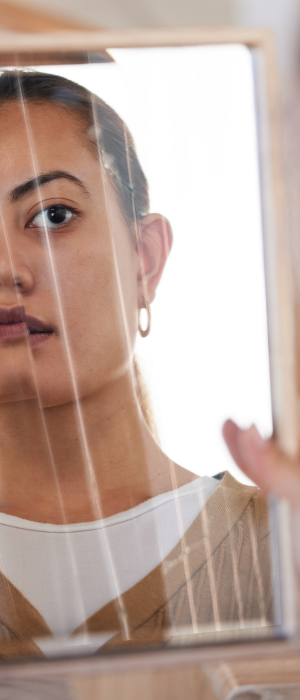 Woman looking into a broken mirror