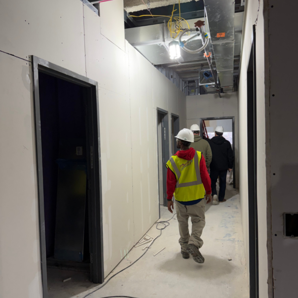 3rd floor BHCC construction photo of a framed hallway with people walking