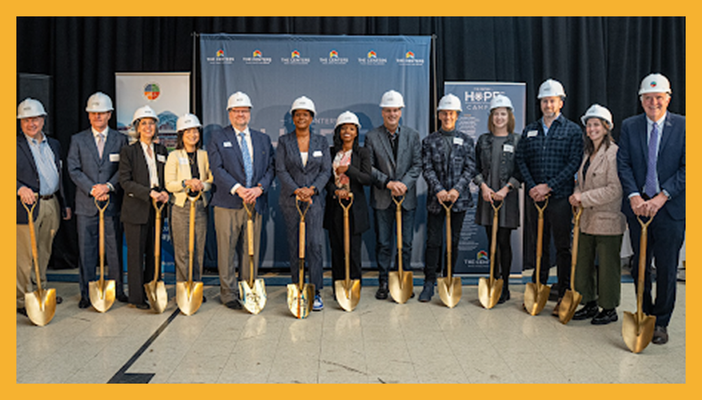A group of people are at a ribbon cutting ceremony with golden shovels